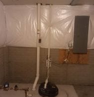 interior radon mitigation system in basement next to sump pump