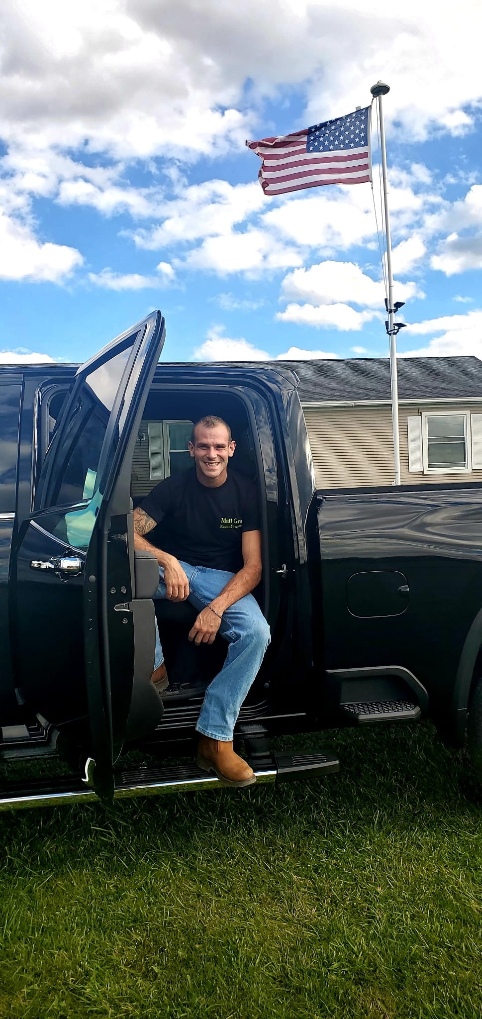Radon Company - Matthew Gray sitting in truck in front of American flag
